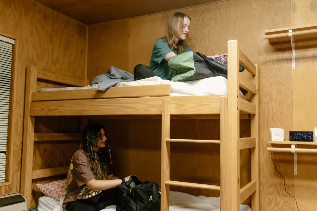 Two campers sitting on a bunk bed
